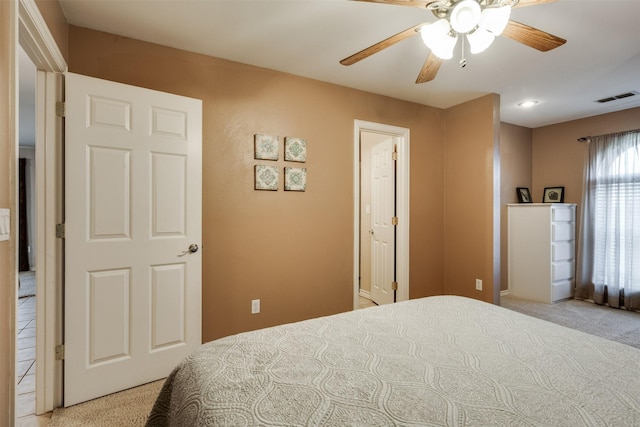 bedroom with light carpet, a ceiling fan, and visible vents