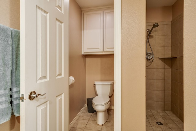 bathroom featuring toilet, tile patterned floors, and a stall shower