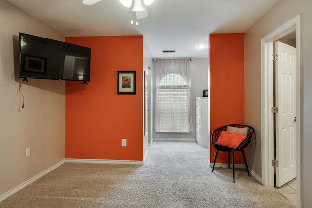 living area featuring ceiling fan, baseboards, carpet flooring, and visible vents