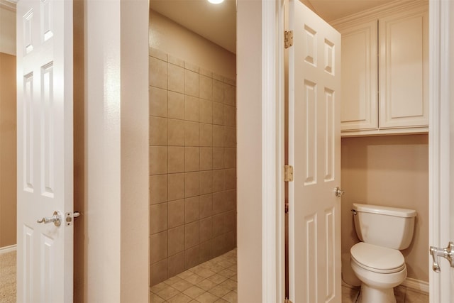 bathroom with a tile shower and toilet