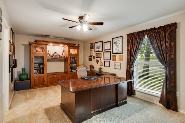 home office featuring ceiling fan, light carpet, and baseboards