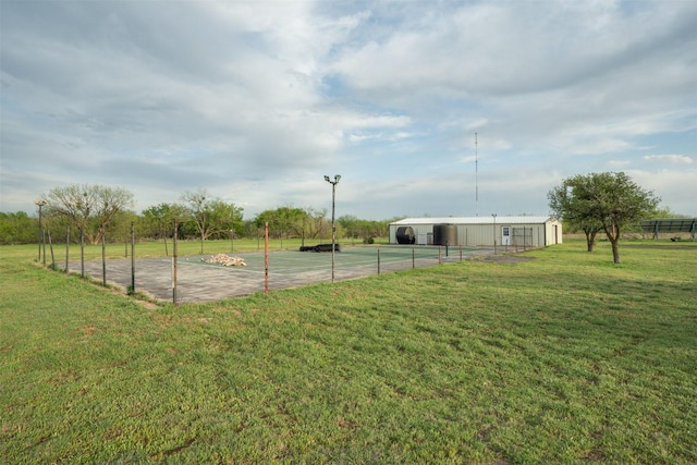exterior space featuring a lawn, an outdoor structure, fence, and a pole building