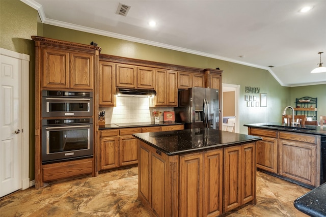 kitchen with a sink, brown cabinetry, stainless steel fridge, ornamental molding, and visible vents