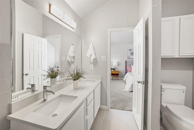 full bathroom featuring double vanity, lofted ceiling, toilet, and a sink