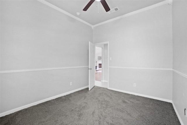 empty room featuring carpet flooring, visible vents, baseboards, ceiling fan, and crown molding