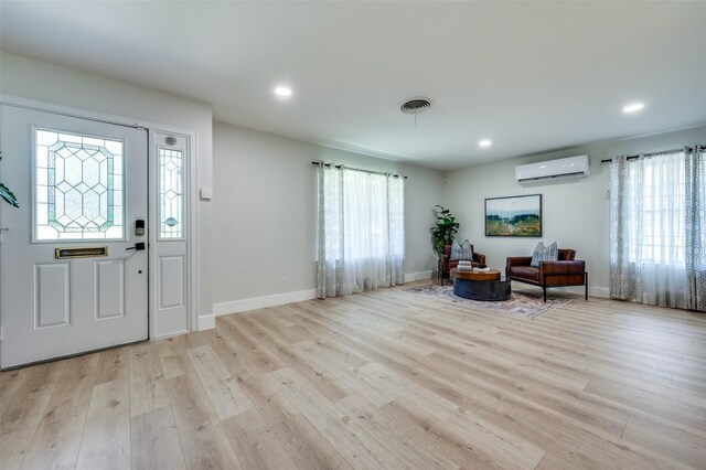 entryway with an AC wall unit, wood finished floors, recessed lighting, and baseboards