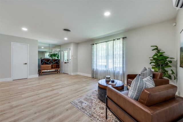 living area featuring healthy amount of natural light, light wood-style flooring, baseboards, and recessed lighting