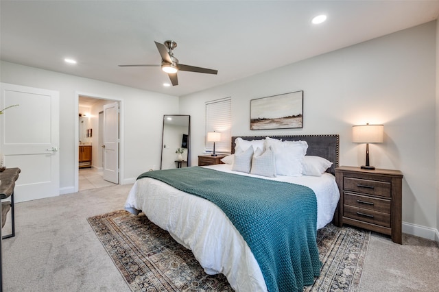 bedroom featuring light carpet, baseboards, recessed lighting, ceiling fan, and ensuite bath