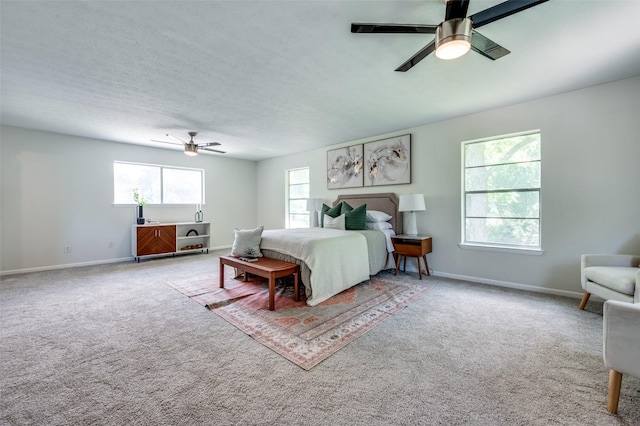 carpeted bedroom featuring baseboards and a ceiling fan
