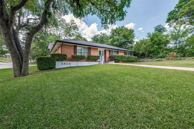 view of front of home featuring a front lawn and brick siding