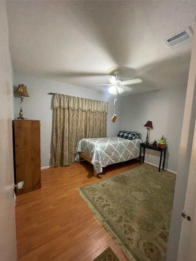 4514 Wyoming St, Dallas, TX 75211 - bedroom featuring wood finished floors, a textured ceiling, and ceiling fan