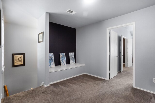 empty room featuring baseboards, carpet flooring, and visible vents