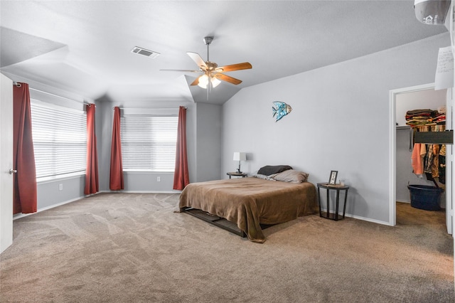 carpeted bedroom with a spacious closet, ceiling fan, baseboards, and visible vents