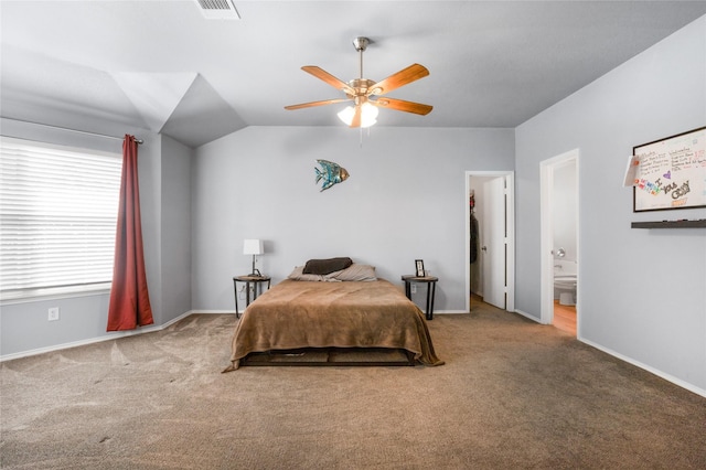 bedroom with visible vents, connected bathroom, carpet, and vaulted ceiling