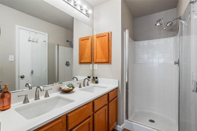 bathroom with a sink, double vanity, and tiled shower