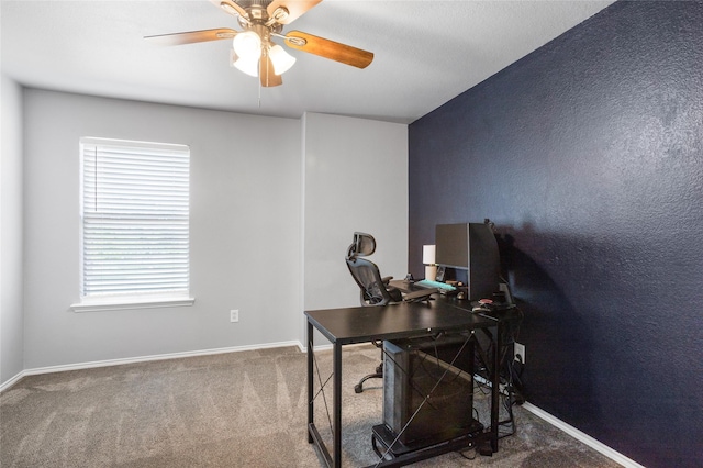 carpeted home office featuring baseboards and a ceiling fan