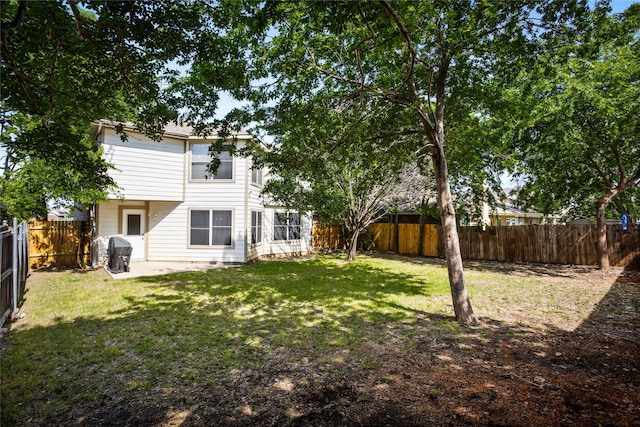 rear view of property with a fenced backyard, a patio area, and a yard