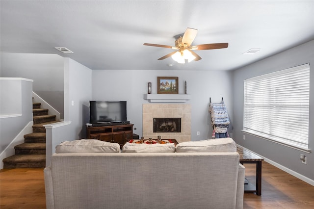 living area with stairway, ceiling fan, wood finished floors, and visible vents