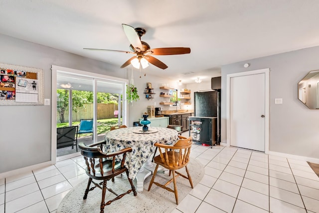 dining space with a ceiling fan, baseboards, and light tile patterned floors