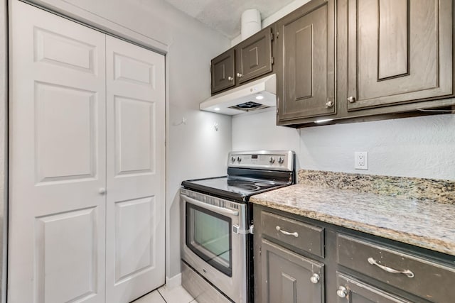 kitchen with stainless steel electric stove, light stone countertops, under cabinet range hood, and light tile patterned floors