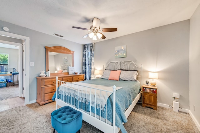 carpeted bedroom with visible vents, baseboards, and ceiling fan