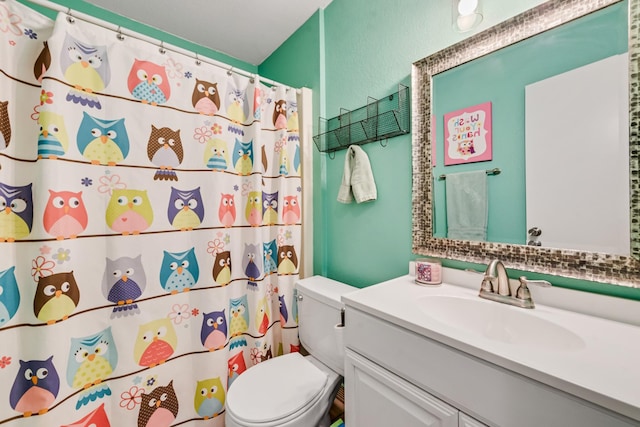 bathroom featuring curtained shower, toilet, and vanity