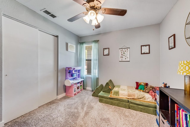 bedroom with visible vents, a closet, baseboards, carpet flooring, and ceiling fan
