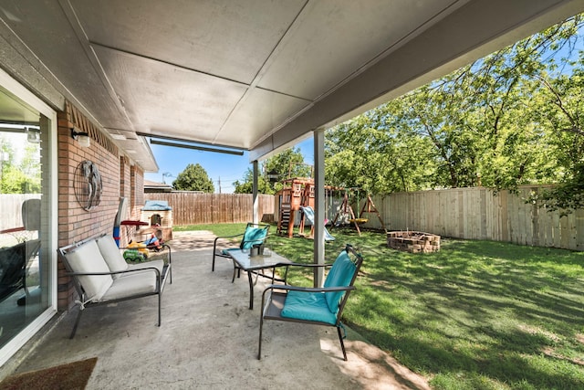 view of patio / terrace featuring a fenced backyard, an outdoor fire pit, and a playground