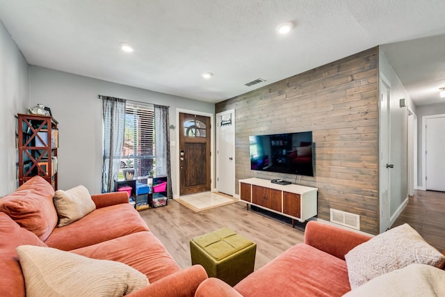 living area featuring recessed lighting, light wood-style floors, visible vents, and baseboards