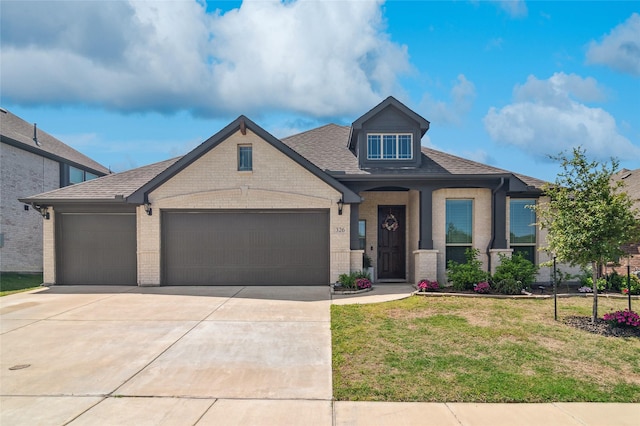 craftsman house with a front lawn, driveway, a garage, brick siding, and roof with shingles