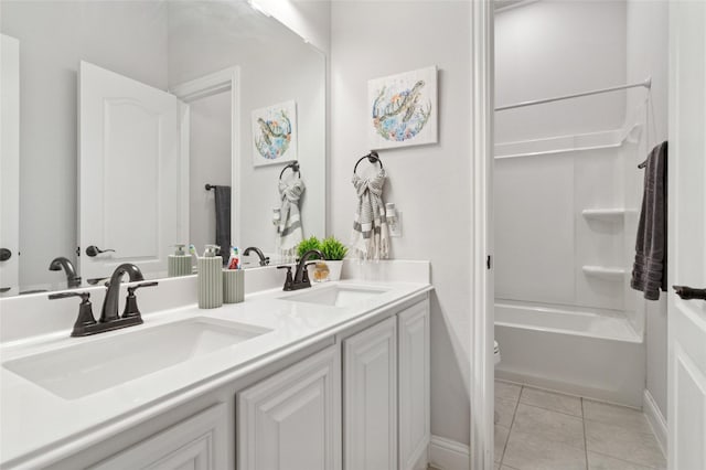 bathroom with double vanity, tile patterned floors, baseboards, and a sink