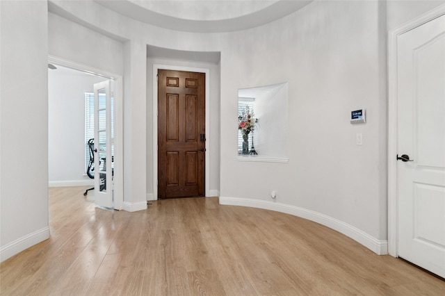 foyer with light wood-type flooring and baseboards