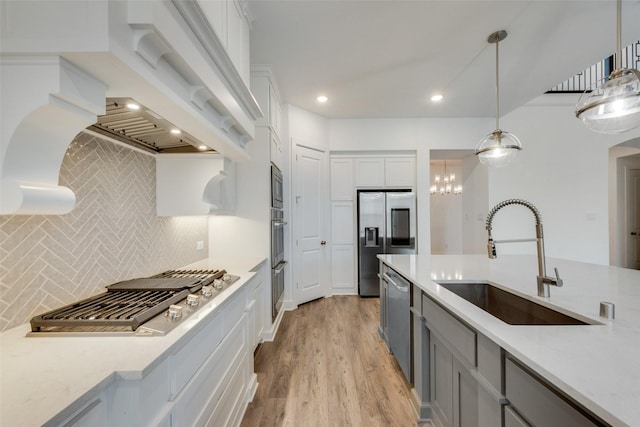4600 Paintbrush Way, Aubrey, TX 76227 - kitchen with light wood-style flooring, a sink, backsplash, pendant lighting, and appliances with stainless steel finishes