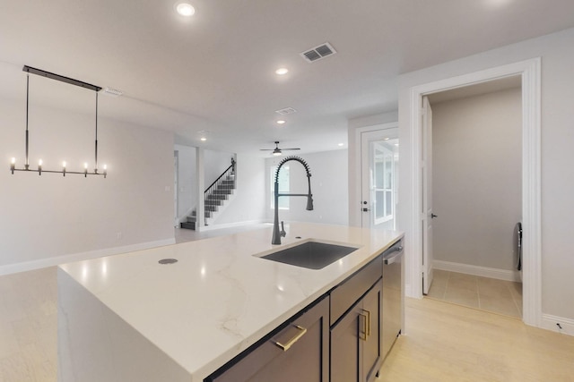 kitchen featuring a kitchen island with sink, a sink, open floor plan, visible vents, and decorative light fixtures