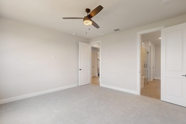 unfurnished bedroom featuring ceiling fan, visible vents, baseboards, and light carpet