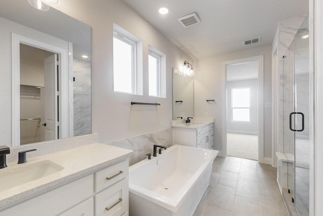 full bath featuring visible vents, a sink, a freestanding bath, and a stall shower