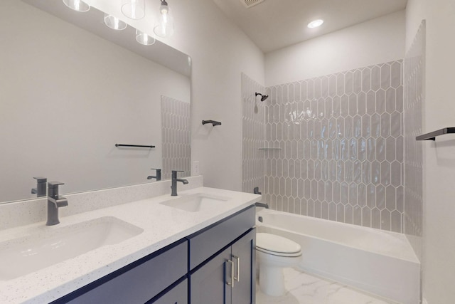 bathroom with washtub / shower combination, marble finish floor, toilet, and a sink