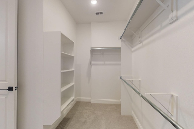 spacious closet featuring visible vents and light carpet