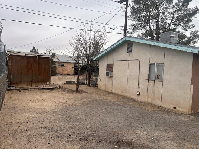 exterior space featuring fence, a chimney, and cooling unit