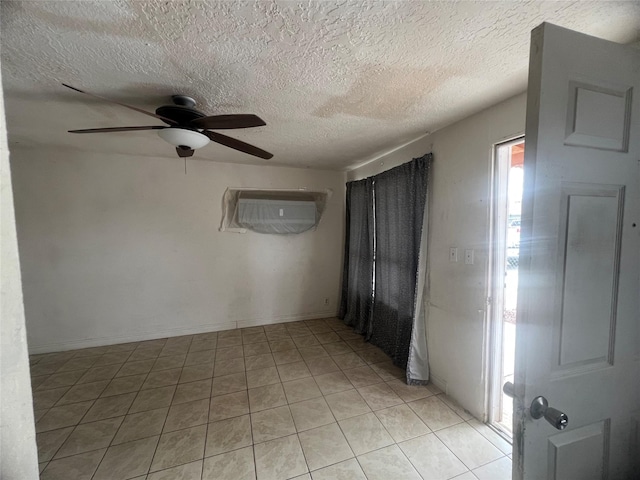 spare room with ceiling fan, a textured ceiling, and light tile patterned floors