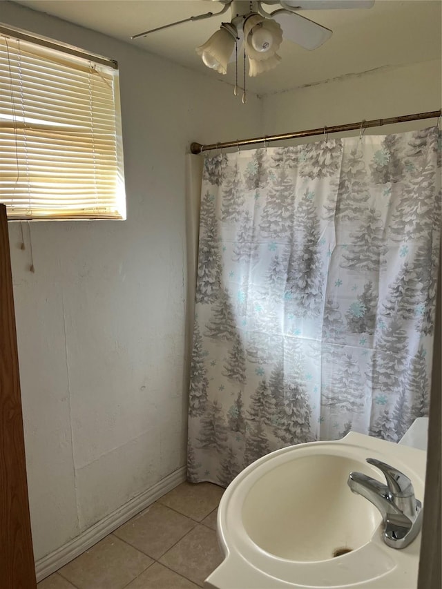 full bath with a shower with shower curtain, tile patterned flooring, a ceiling fan, and a sink