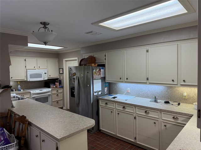 kitchen featuring light countertops, backsplash, visible vents, ornamental molding, and white appliances