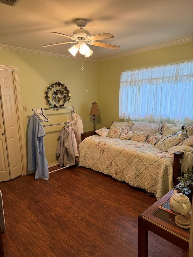 bedroom featuring visible vents, ceiling fan, wood finished floors, and ornamental molding