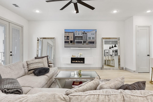 2635 Carmelita St, Dallas, TX 75212 - living room with a ceiling fan, a warm lit fireplace, wood finished floors, and recessed lighting