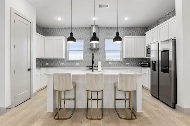 2635 Carmelita St, Dallas, TX 75212 - kitchen with appliances with stainless steel finishes, light wood-style flooring, a kitchen island with sink, light countertops, and recessed lighting