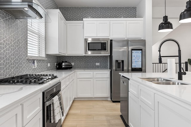 2635 Carmelita St, Dallas, TX 75212 - kitchen featuring stainless steel appliances, extractor fan, light wood finished floors, white cabinetry, and light stone countertops
