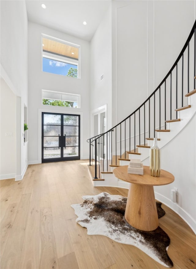 4120 Ridgecrest Dr, Flower Mound, TX 75022 - entryway featuring a towering ceiling, french doors, hardwood / wood-style flooring, and stairs