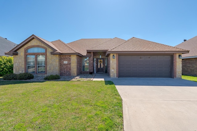 single story home featuring a front lawn, driveway, stone siding, a garage, and brick siding