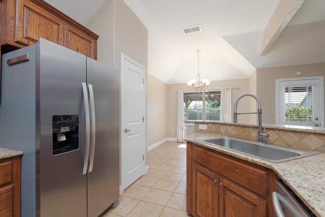 kitchen featuring stainless steel appliances, a sink, light tile patterned flooring, visible vents, and brown cabinets