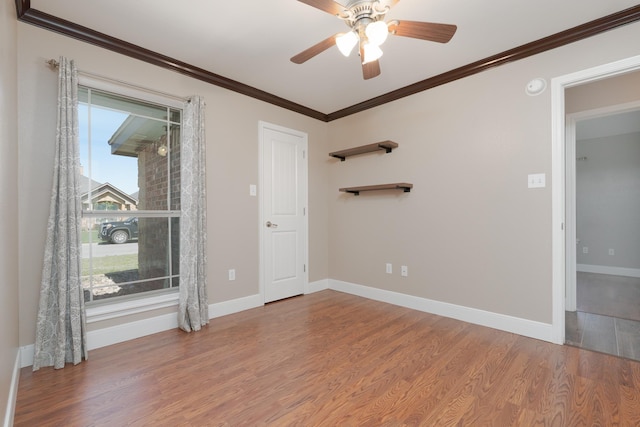 spare room with ceiling fan, baseboards, ornamental molding, and wood finished floors